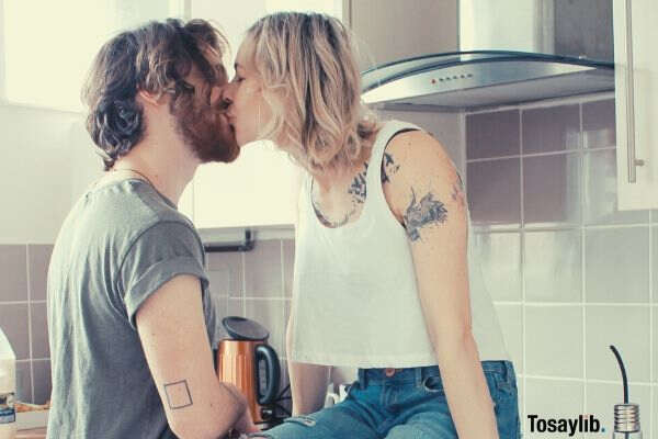 man and woman kissing in the kitchen