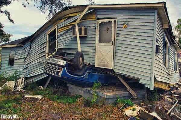 blue car underneath a house