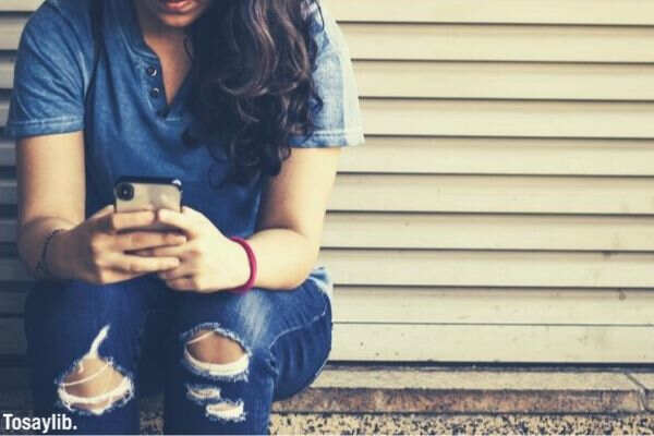 woman sitting by the corner using smartphone