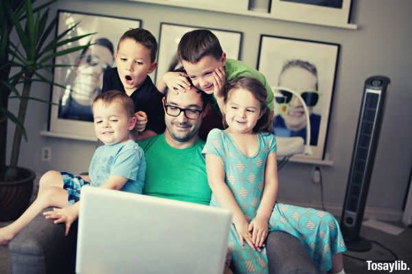 daddy and kids watching on laptop while sitting