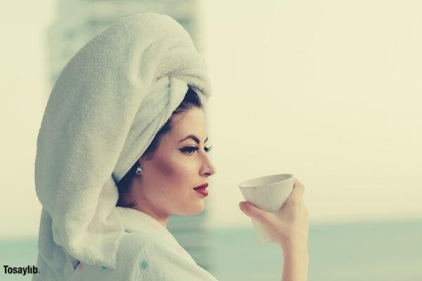 photo of woman wearing bathrobe holding mug