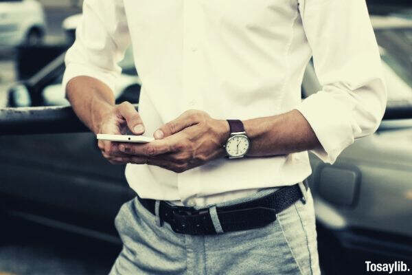 man in white long sleeves using smartphone