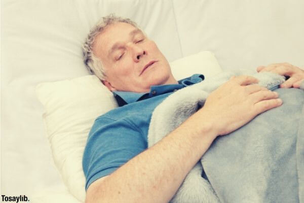 old man lying on bed