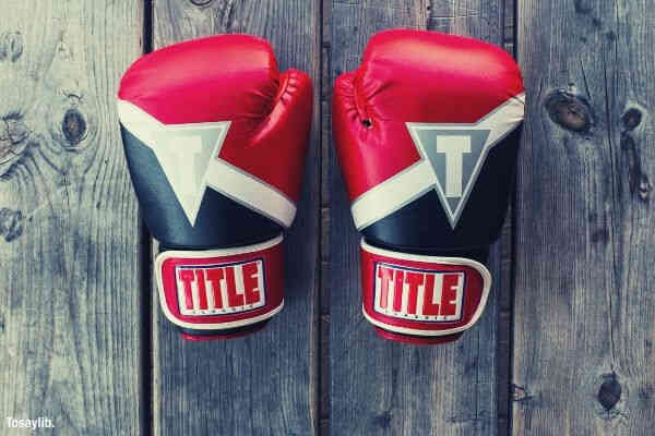 pair black red white title gloves on gray wooden plank