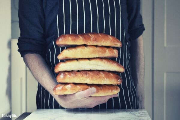 baker holding loaves of bread