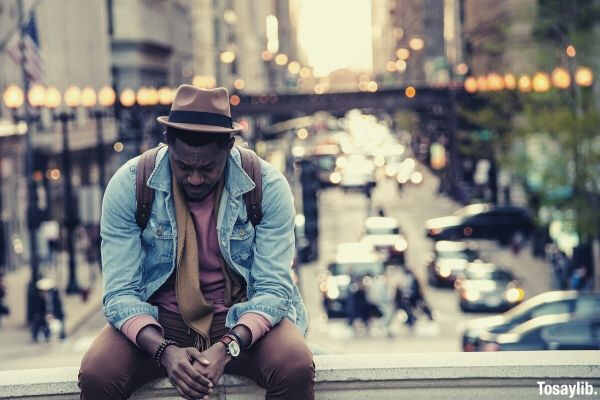 man in jacket and hat looking down