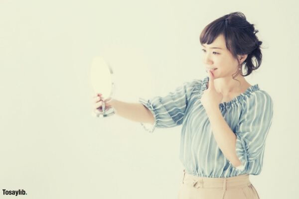 smiling woman looking on mirror light blue top