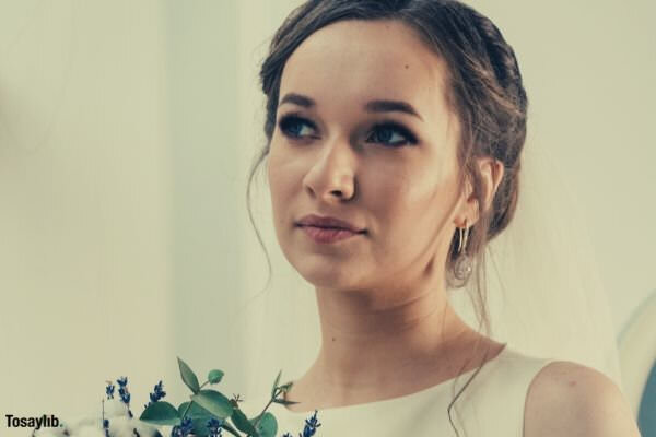 woman wearing white gown holding bouquet of flowers