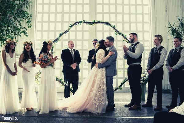 bride groom kissing people guest happy large window