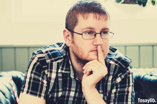 man wearing black plaid shirt sitting