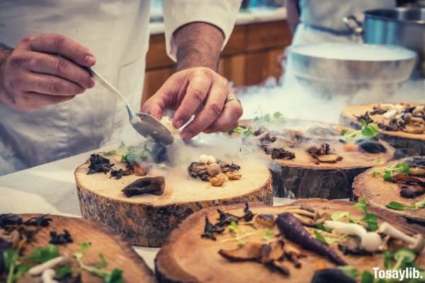 chef preparing vegetable dish on tree slab