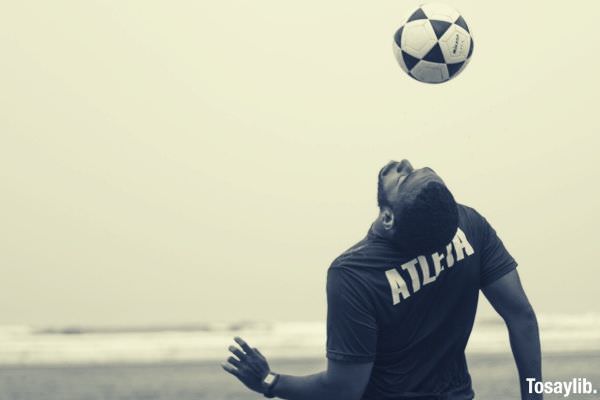 man on shore doing soccer ball tricks