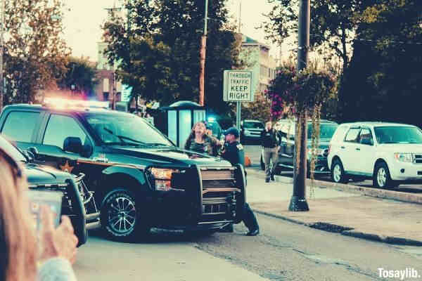 people standing beside black pickup truck