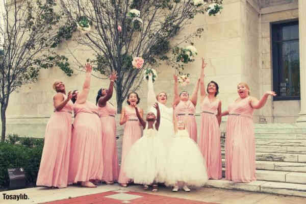 women wearing dresses while throwing bouquets pink motif