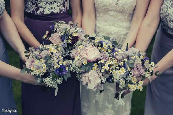 picture of four women holding bouquet pink purple