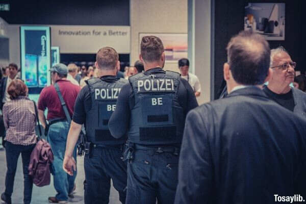 men polizei officers standing in front of people