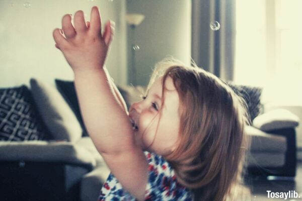 girl catching bubbles