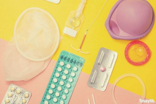 condom and tablet packs yellow and pink background