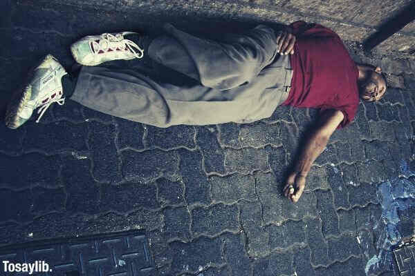 man in red shirt lying on the ground