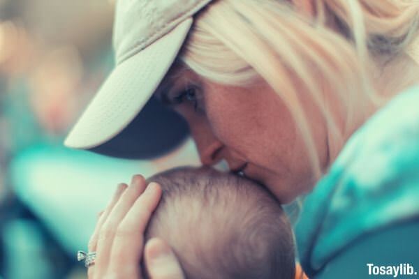 portrait of a woman kissing baby s head