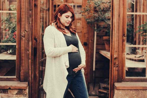 pregnant-woman-holding-her-tummy-near-garden