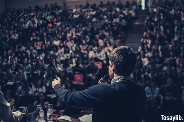 man speaking in front of crowd