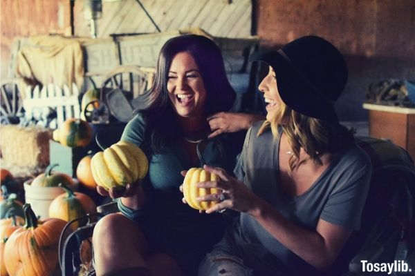two women holding pumpkin