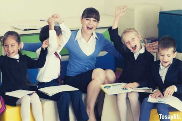 elementary school students and teacher sitting in a cube cushion