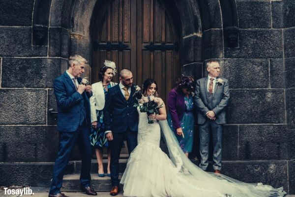 wedding couple behind closed door with parents