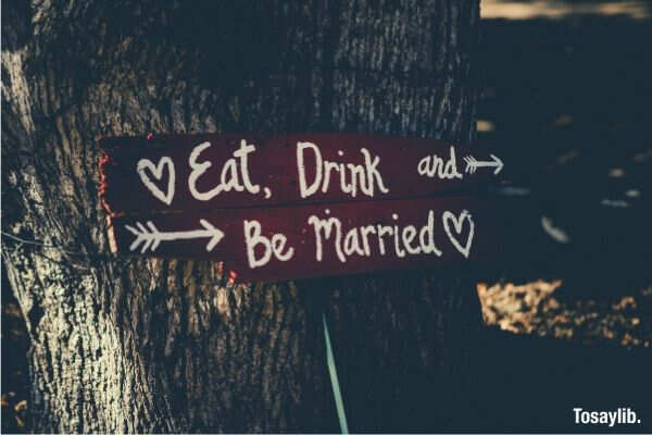 red white eat drink and be married signage on bark of tree