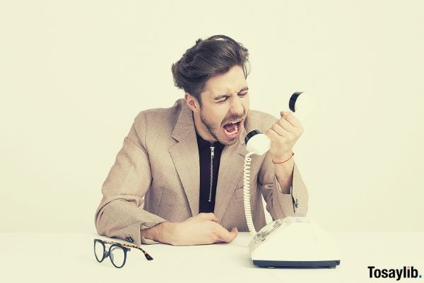 man holding telephone shouting