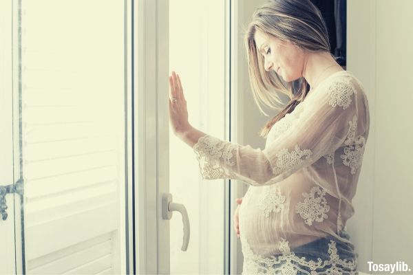 01 photo of pregnant woman standing in front of door