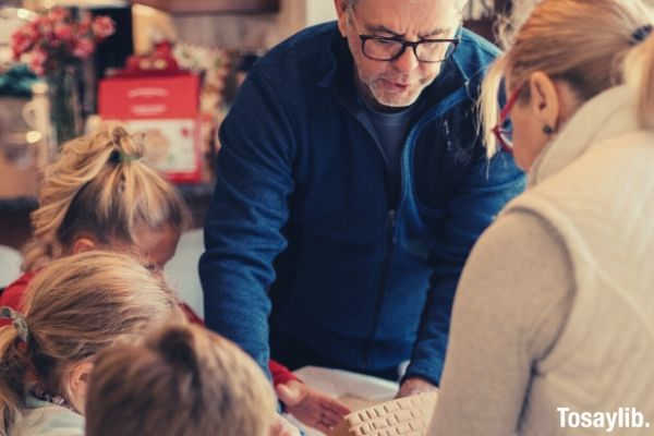 one man and one woman standing in front of three kids