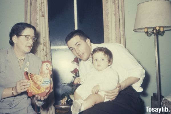 man in white shirt holding a baby