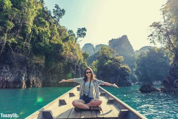 photo of a woman sitting on a boat raising her hand