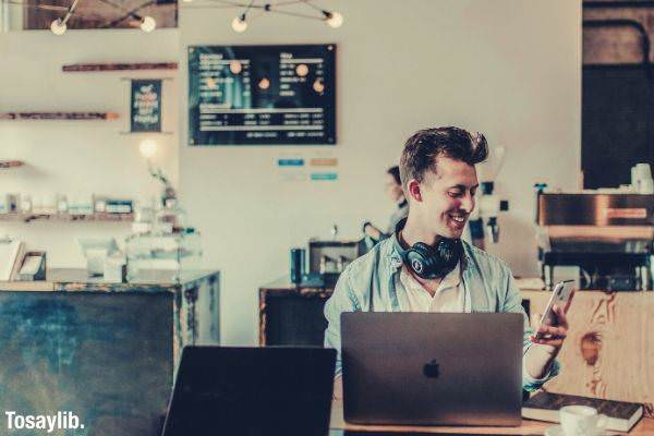 man using laptop phone headset