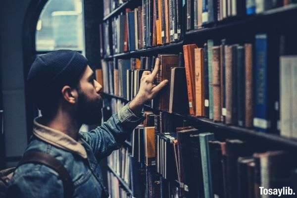 man looking for books library