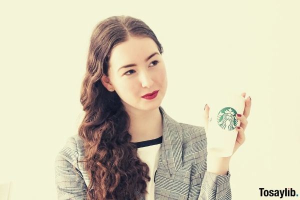 woman in gray coat with starbucks cup
