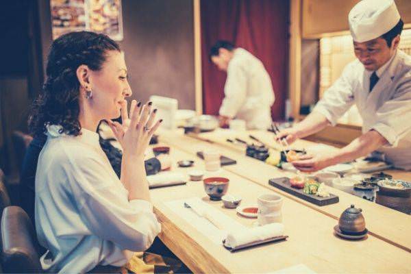 woman-sitting-looking-at-the-sushi