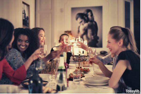 group of people sitting around table with plates and drinking glasses