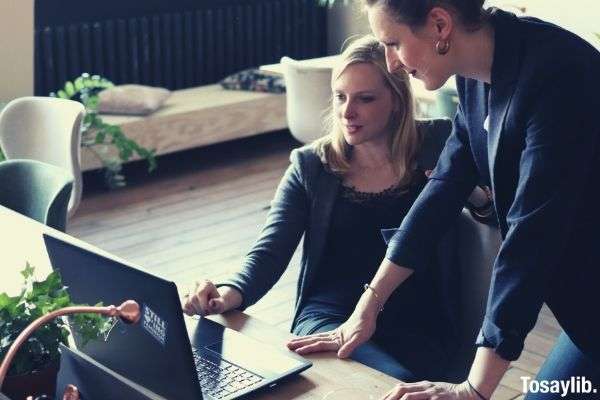 two women using black laptop