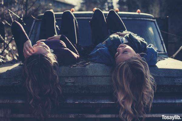 03 two women lying down on vehicle