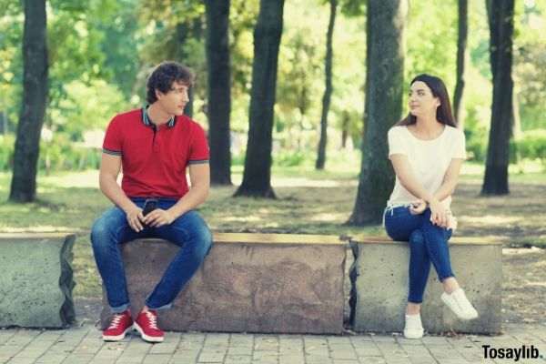 10 man sitting on a bench at the park girl looking at him