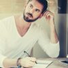 feature-smart-businessman-thinking-while-writing-on-notebook-at-sidewalk-cafe