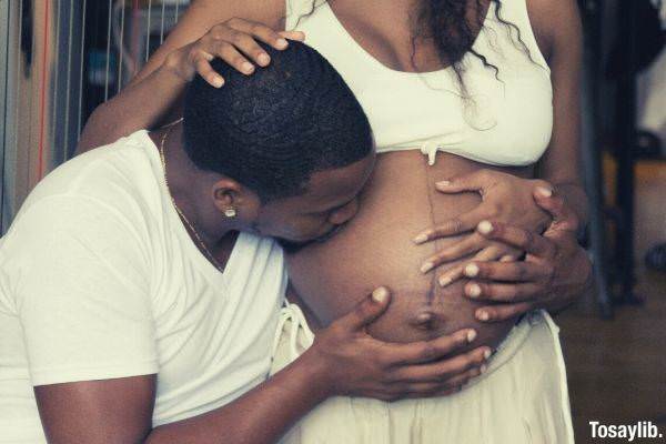 man kissng woman s stomach pregnant woman