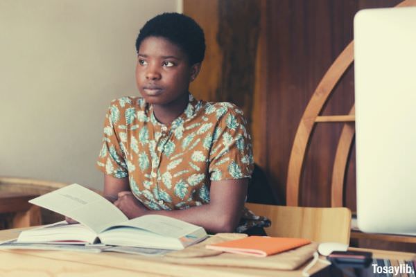 photo of a black woman short hair holding a book