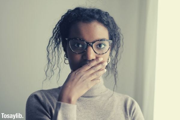 surprised woman looking at camera wearing eyeglasses in studio