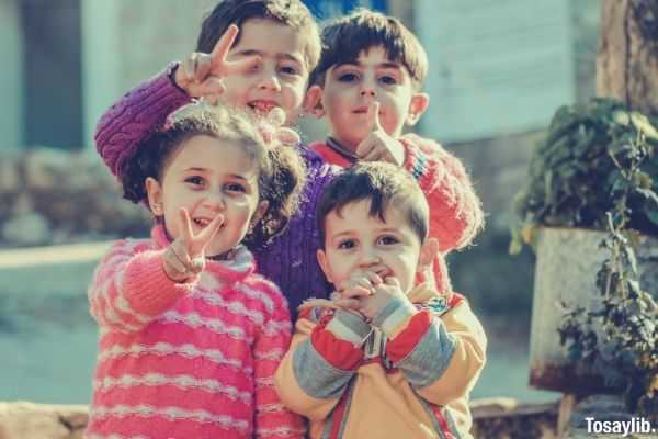 Photo of four happy children wearing colorful clothes