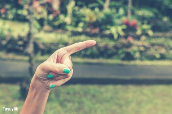 hand pointing neon color nails grass