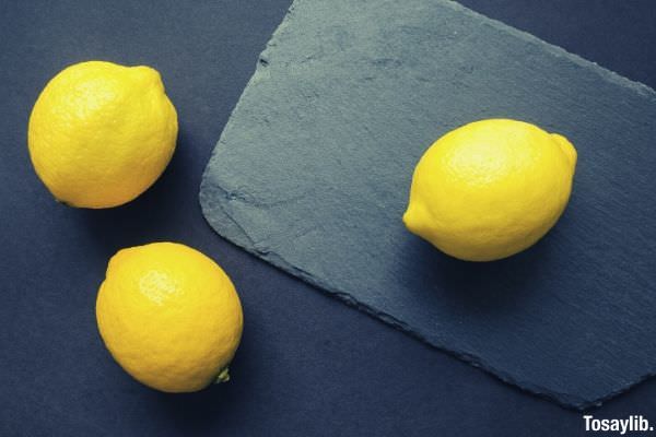 three yellow citrus lemon on top of black table